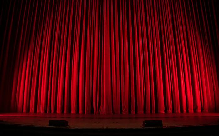 red theater curtain by Rob Laughter courtesy of Unsplash.